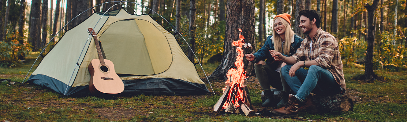 couple camping next to fire