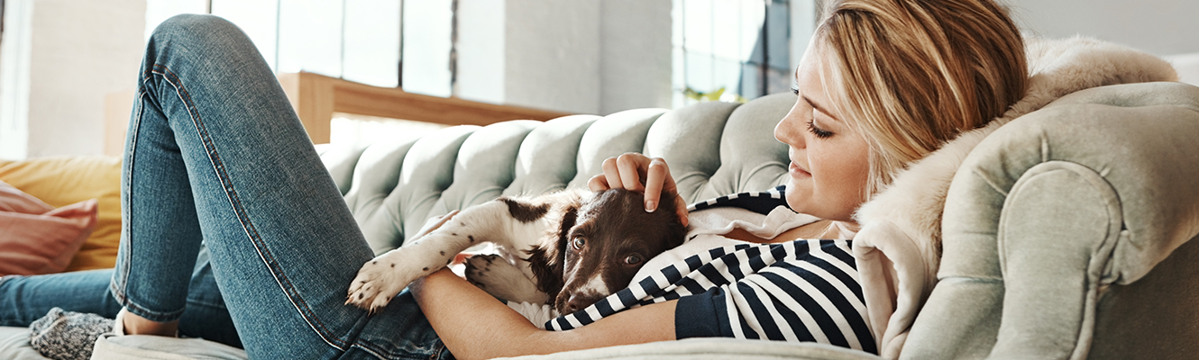 woman laying on couch with dog