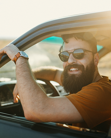 Bearded man in car smiling
