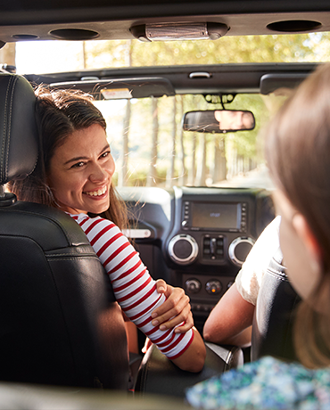 Mom looking at kids in backseat of car