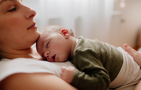 mother with sleeping baby on chest