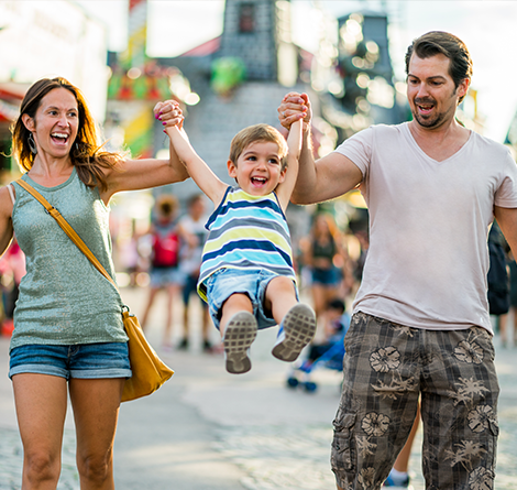 parents swinging kid as they walk