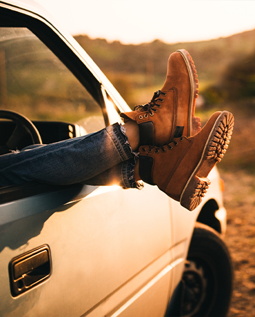 persona hanging feet out of car window