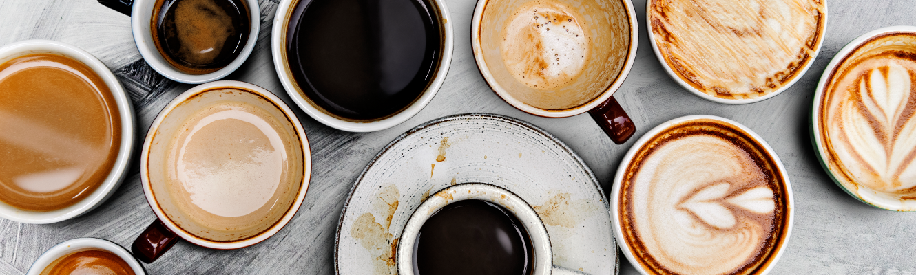 A group of espresso cups and coffee cups on a table.