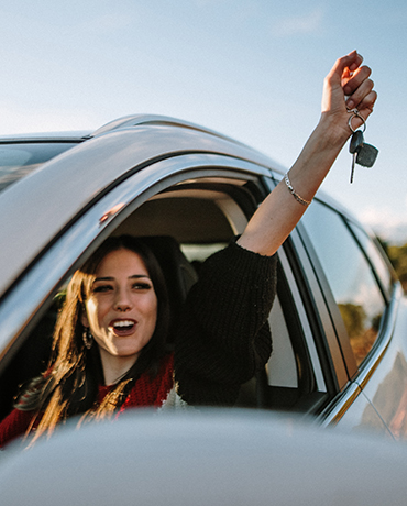 Woman in a car holding up her car keys