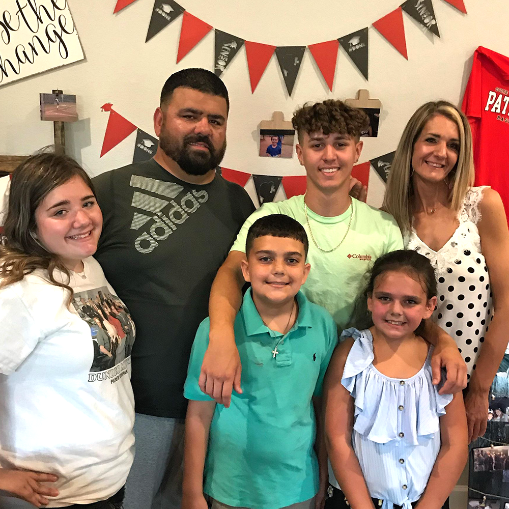 A family standing together and smiling.