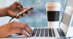 A woman working on a laptop with coffee