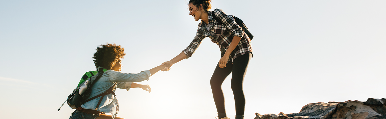 a woman helping pull a man up