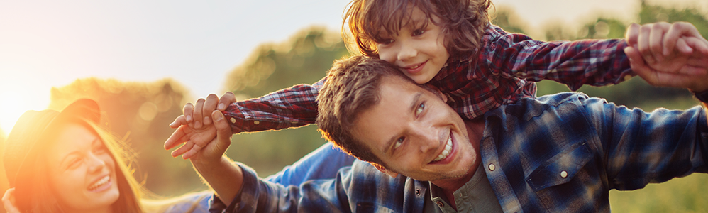 Dad giving child piggy back ride