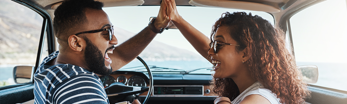 couple giving each other a high five in car