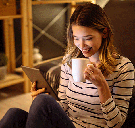 woman on ipad sipping hot chocolate