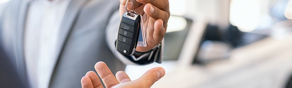 two hands passing a set of car keys