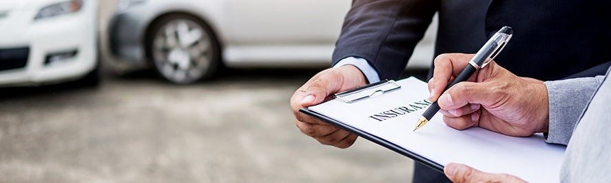 man signing papers on clipboard