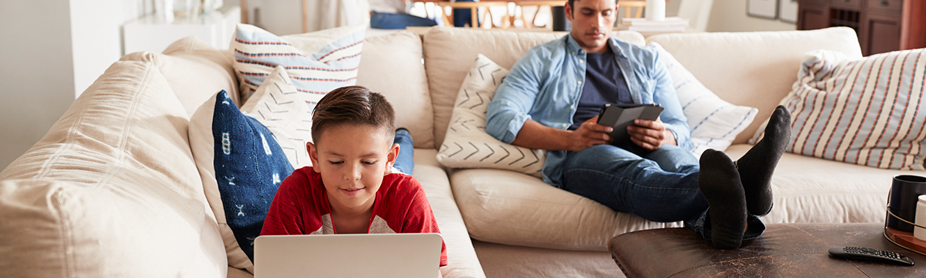 Family in the living room on their phones & tablet.