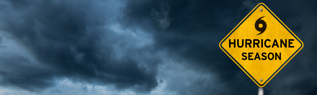 A hurricane season sign with clouds in the background.
