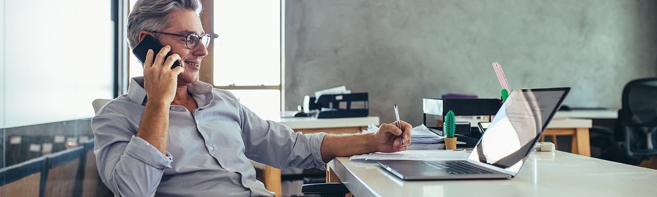 man at desk on phone