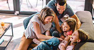 parents tickling girls on couch