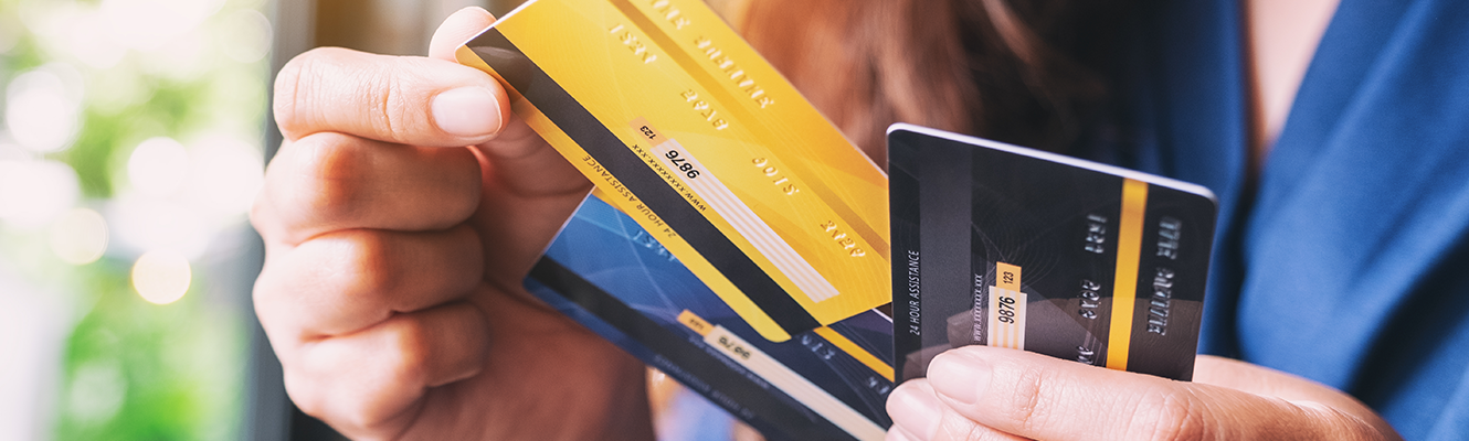 woman holding three credit cards