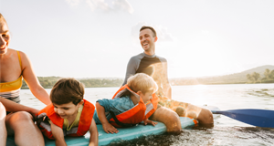 11:26 AMClaude responded: Family enjoying a sunny day on the lake, with young children wearing orange life jackets playing on a paddleboard, accompanied by smiling adults outdoors.Family enjoying a sunny day on the lake, with young children wearing orange life jackets playing on a paddleboard, accompanied by smiling adults outdoors.