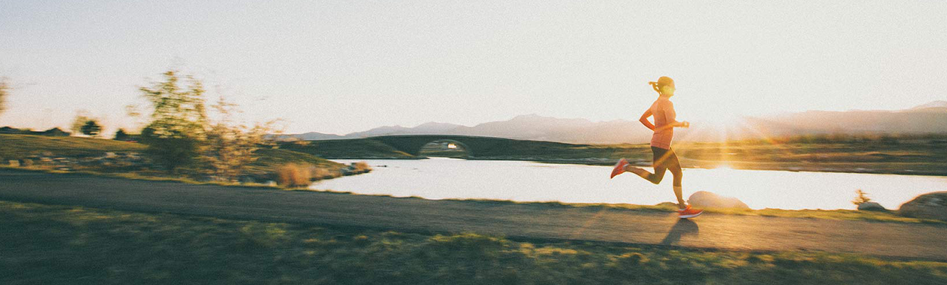 A woman running down a hiking trail.