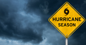 A hurricane season sign with clouds in the background.