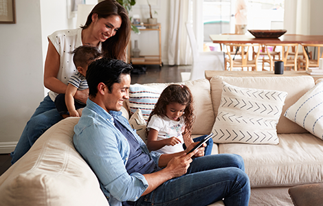 family on couch using ipad