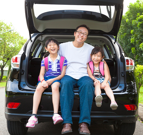 Dad and daughters in back of SUV