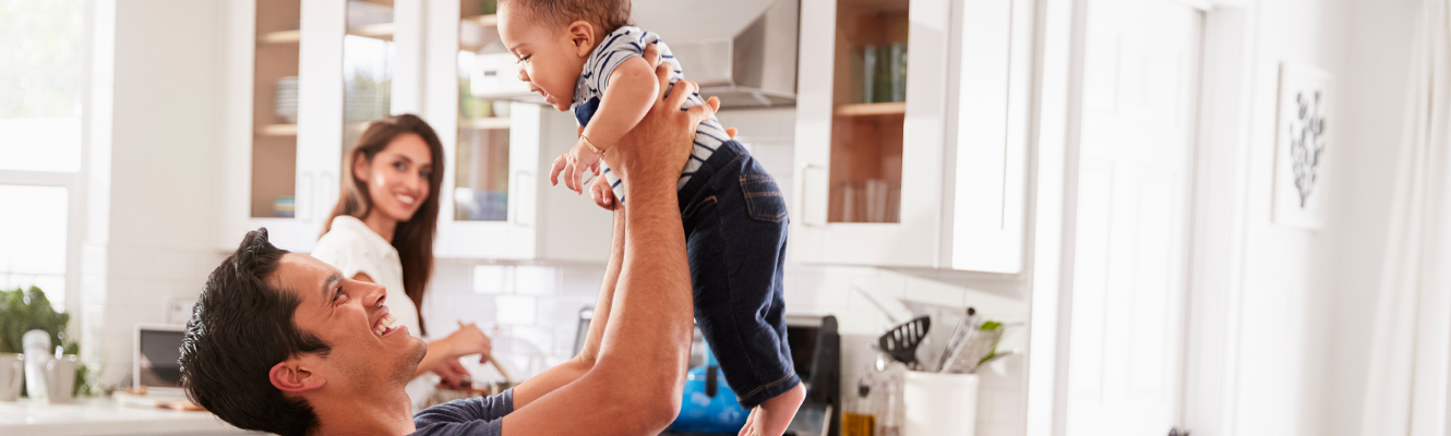 Man holding baby above head