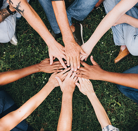 people in circle touching hands