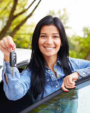 woman standing at car with keys in hand