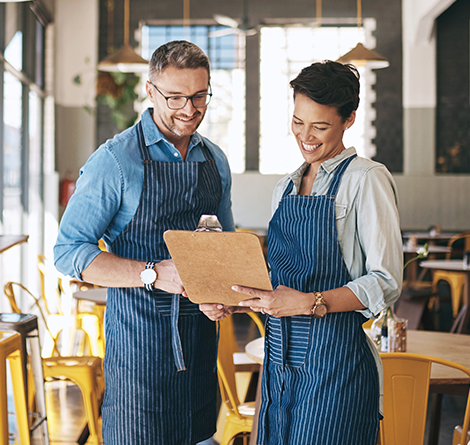 Two serves looking over a menu