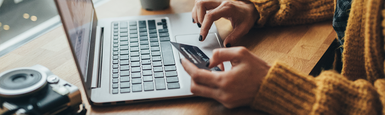 woman on laptop looking at credit card