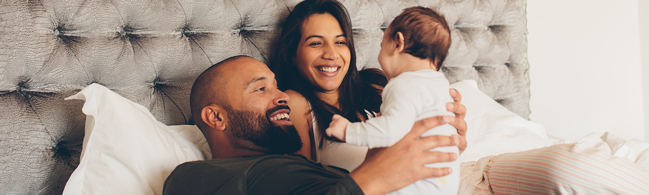 parents snuggling with baby