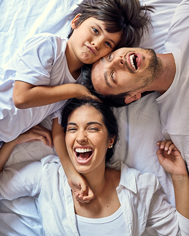 Parents and son in bed snuggling